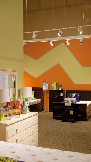 Ashley Furniture HomeStore lights a n accent wall with Track heads using LED Lamps