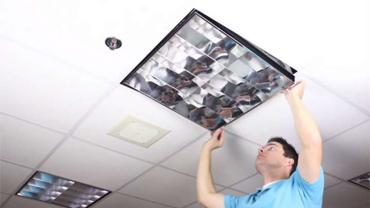 Man installing lighting equipment in ceiling
