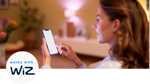 Woman controlling the lights in her living rooms with her smartphone