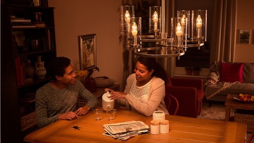 Woman screwing in a consumer light bulb at home