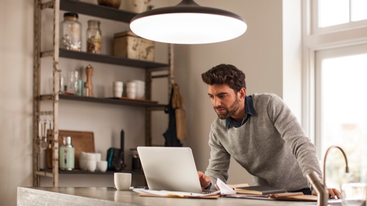 a man working at home under a smart luminaire